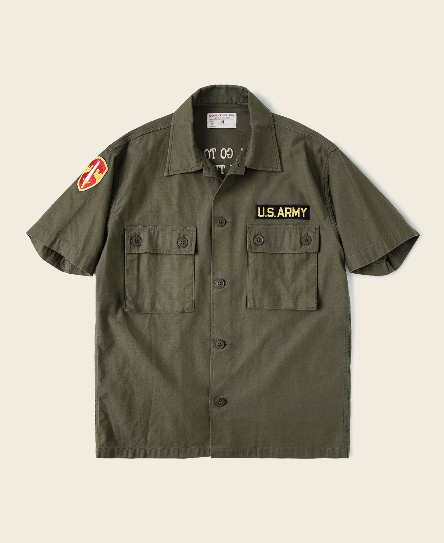 Chemise utilitaire boutonnée à manches courtes vert olive, avec écusson militaire