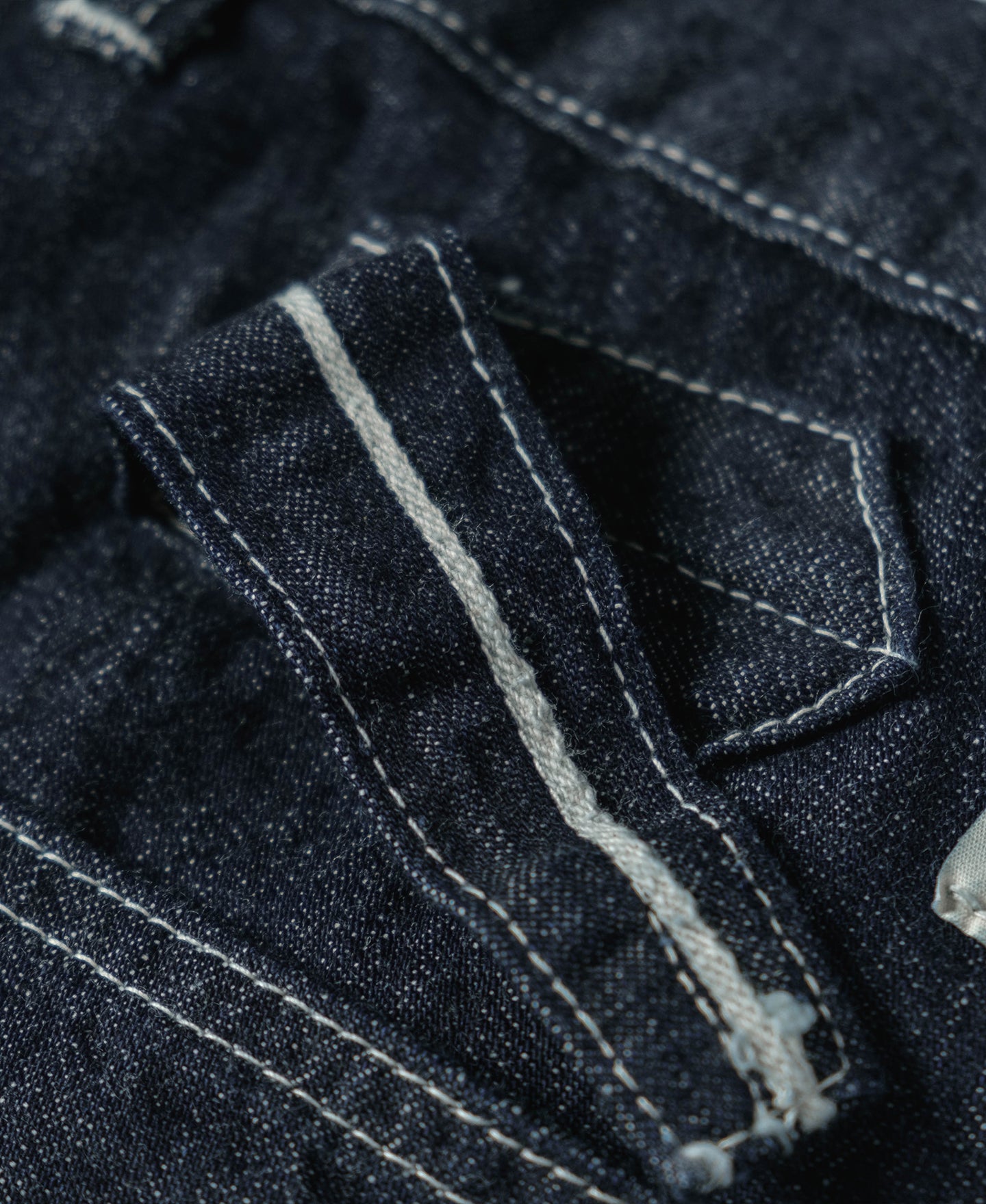 Jean en denim indigo coupe large style workwear avec surpiqûres contrastantes, poches plaquées et coupe fatigue